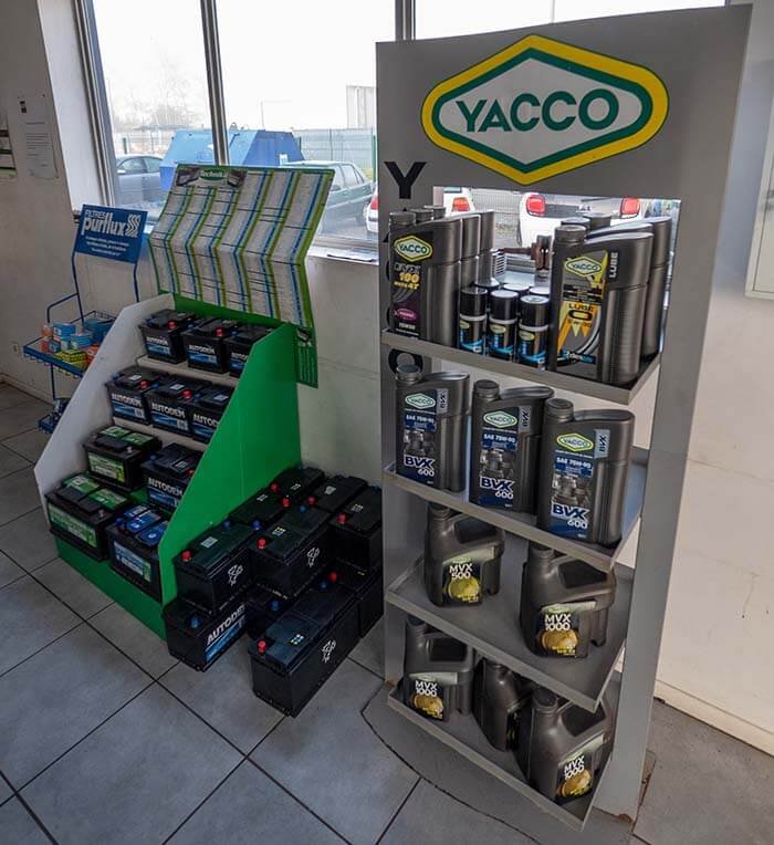 Présentoir de produits Yacco et batteries automobiles dans le garage.