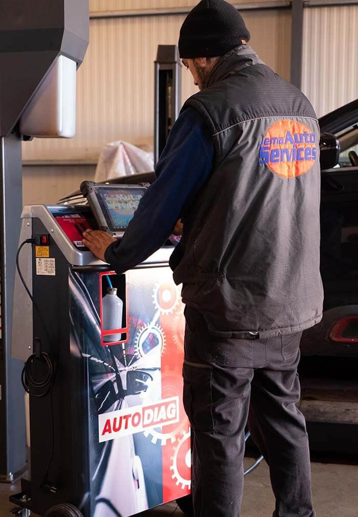 Technicien utilisant une machine de diagnostic AutoDiag dans le garage.